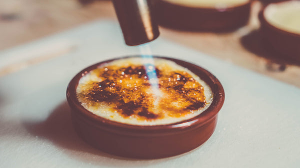 Crème brûlée torch caramelising sugar with a jet flame